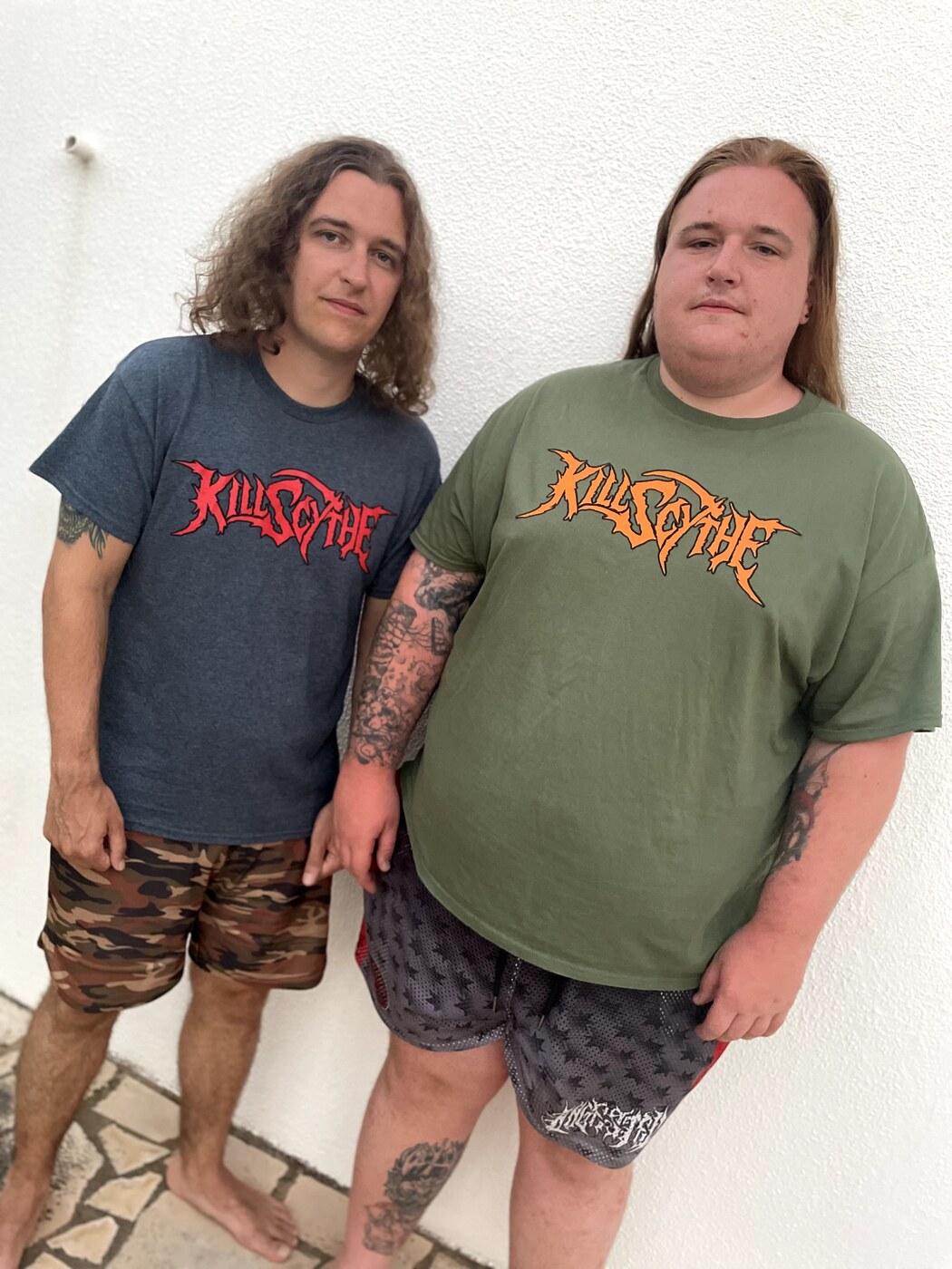 Two KillScythe fans wearing the KillScythe t-shirt in navy and olive green